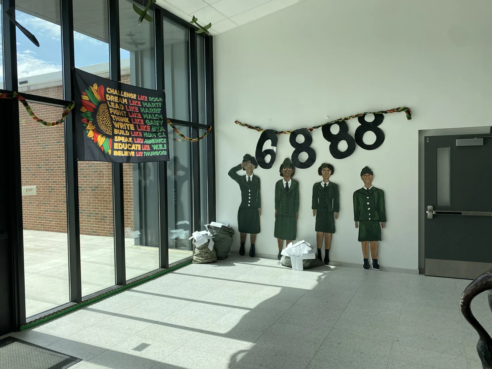 school foyer with 4 hand painted black women in armed forces uniforms and Black History Month banner