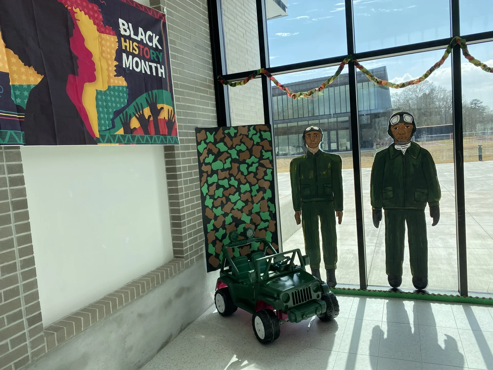 school foyer with 2 hand painted black men in Air Force uniforms and Black History Month banner