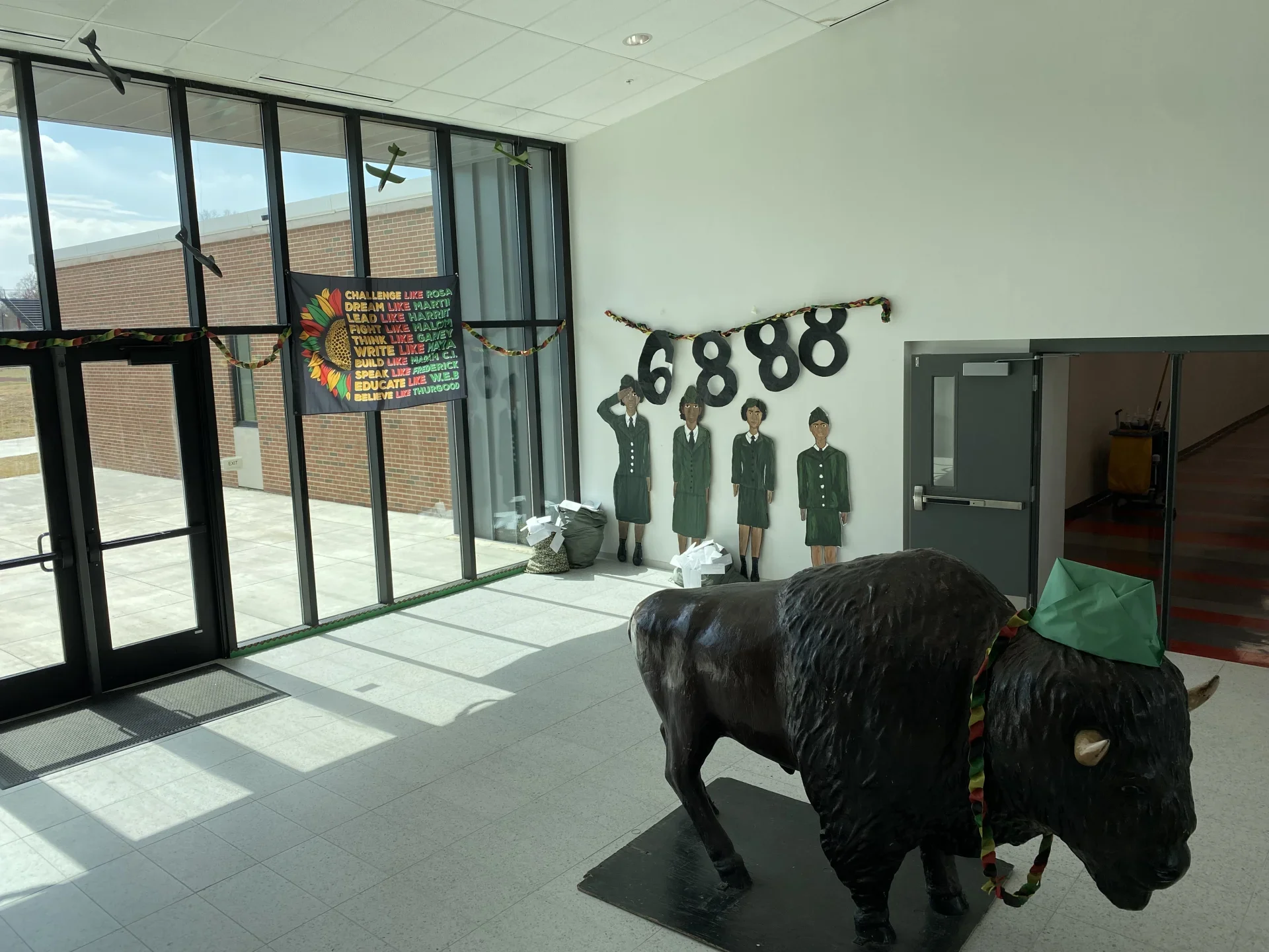 school foyer with 4 hand painted black women in armed forces uniforms and Black History Month banner