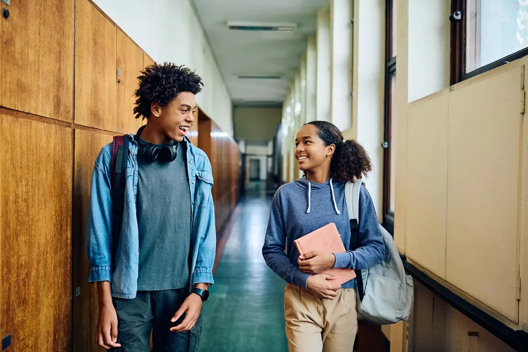 two happy students walking in hallway