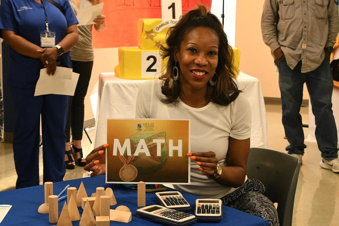 a teacher with a math sign and 2 calculators