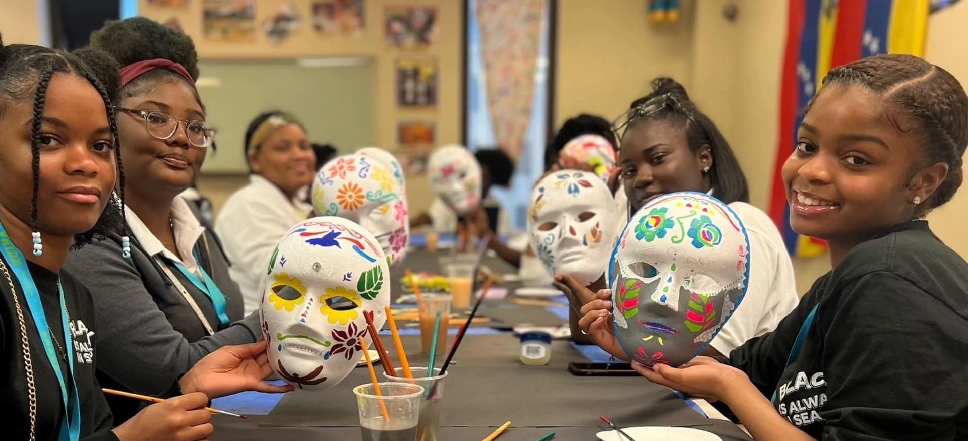 students holding decorative masks